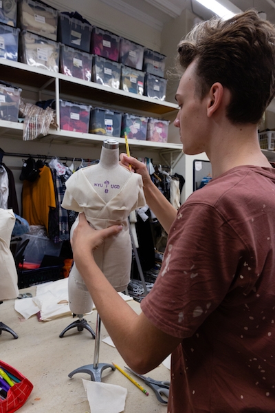Student draping muslin onto his dress form.
